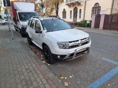 Белый Renault Duster первого поколения с передней защитной дугой: вид спереди и сбоку